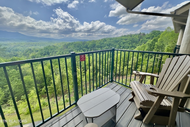 balcony featuring a wooded view
