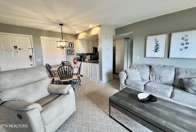 living room with a chandelier, light carpet, recessed lighting, and baseboards
