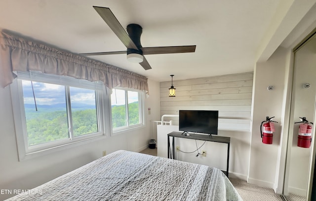 carpeted bedroom with baseboards and ceiling fan