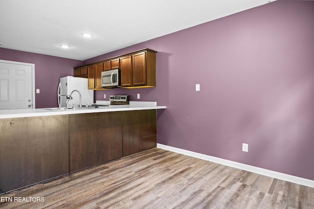 350 Hartfield Ln, Loudon, TN 37774 - kitchen featuring stainless steel microwave, stove, light wood-style flooring, freestanding refrigerator, and a sink