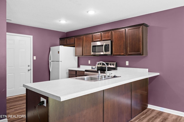 350 Hartfield Ln, Loudon, TN 37774 - kitchen featuring appliances with stainless steel finishes, light countertops, dark wood-type flooring, a peninsula, and dark brown cabinetry