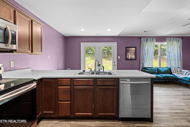 350 Hartfield Ln, Loudon, TN 37774 - kitchen with appliances with stainless steel finishes, a sink, a peninsula, open floor plan, and light wood-type flooring