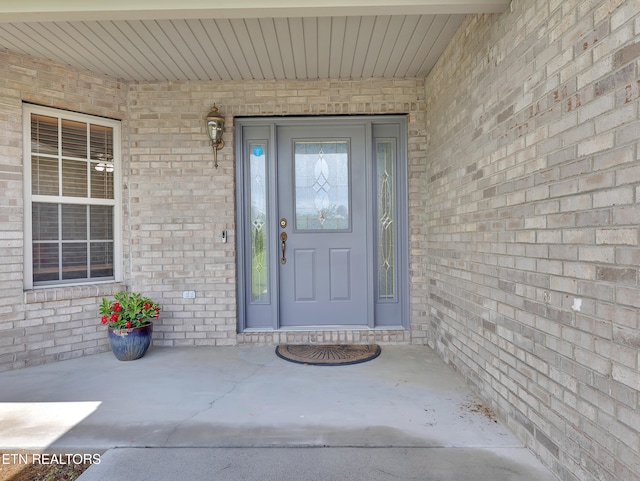 view of exterior entry with brick siding