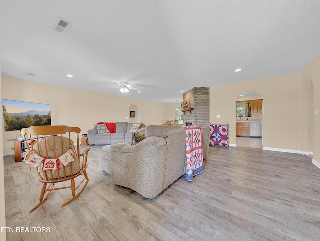 living room with arched walkways, ceiling fan, light wood-type flooring, recessed lighting, and baseboards