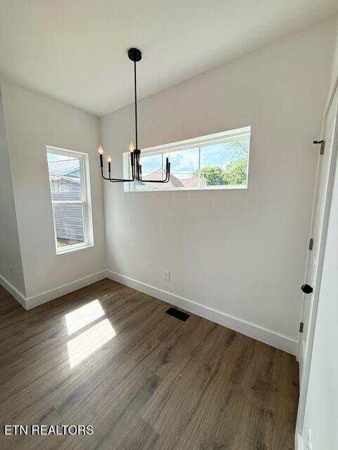 1118 NW Mercer St, Knoxville, TN 37921 - unfurnished dining area featuring healthy amount of natural light, baseboards, and a chandelier