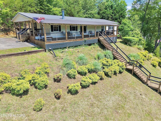 view of front of property featuring covered porch, stairs, and metal roof