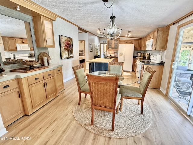 dining space featuring crown molding, light wood finished floors, a chandelier, a textured ceiling, and baseboards