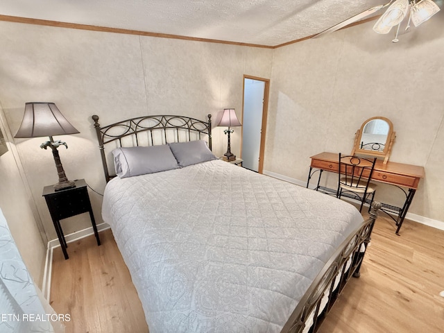 bedroom with wood finished floors, a textured ceiling, ornamental molding, and lofted ceiling