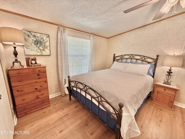 bedroom with ornamental molding, wood finished floors, a textured ceiling, and a ceiling fan