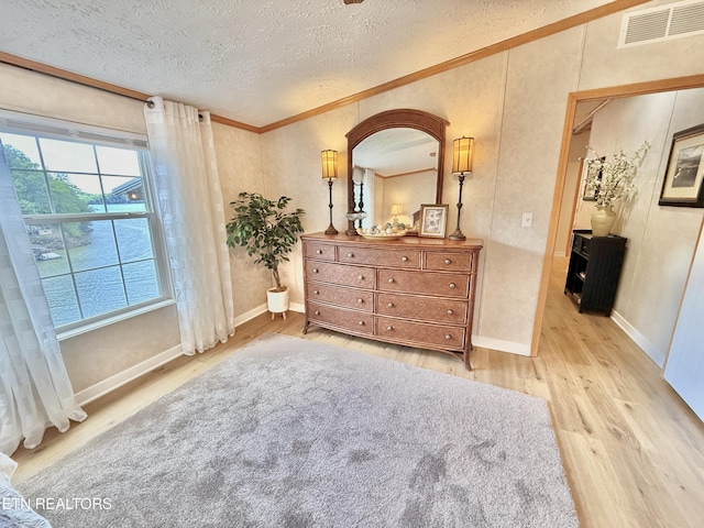 bedroom with light wood-type flooring, a textured ceiling, ornamental molding, arched walkways, and baseboards
