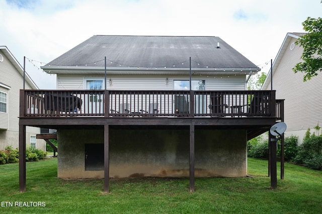 rear view of property featuring a wooden deck and a yard