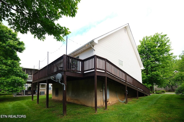 rear view of house featuring a deck and a lawn
