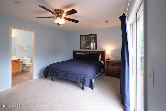 bedroom featuring light carpet, ensuite bath, a ceiling fan, and baseboards