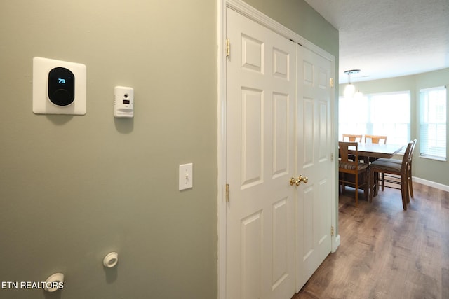 hall featuring wood finished floors and baseboards