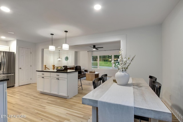 133 Nebraska Ave, Oak Ridge, TN 37830 - kitchen with stainless steel refrigerator with ice dispenser, light wood finished floors, white cabinetry, a breakfast bar, and dark countertops