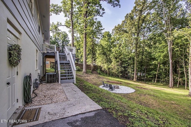 133 Nebraska Ave, Oak Ridge, TN 37830 - view of green lawn featuring stairs, an outdoor fire pit, central AC unit, and a wooden deck