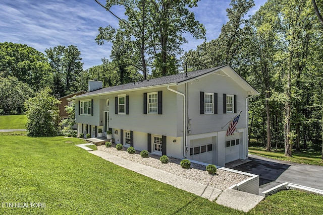 133 Nebraska Ave, Oak Ridge, TN 37830 - raised ranch featuring asphalt driveway, an attached garage, a front lawn, and view of scattered trees