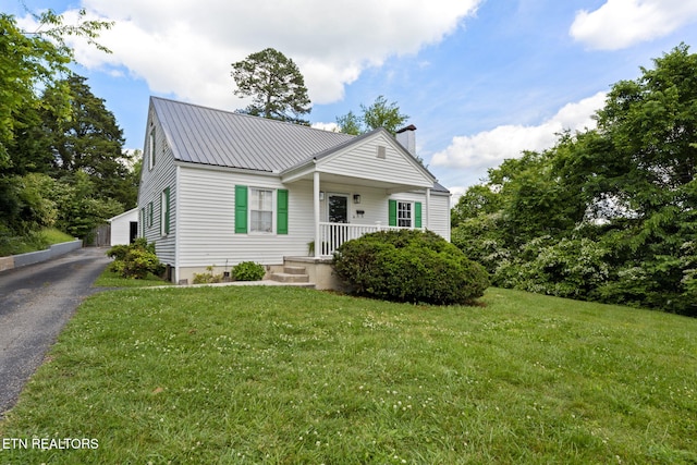 313 Lamar Ave, Clinton, TN 37716 - view of front of house with a chimney, a front lawn, metal roof, and a detached garage