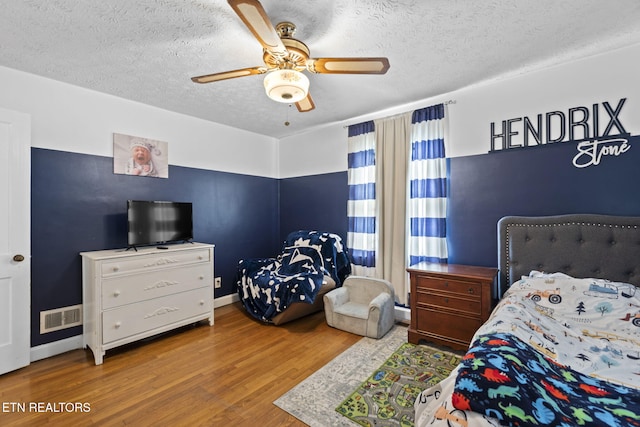 313 Lamar Ave, Clinton, TN 37716 - bedroom featuring wood finished floors, a textured ceiling, baseboards, and a ceiling fan
