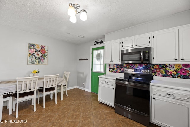 313 Lamar Ave, Clinton, TN 37716 - kitchen featuring stainless steel microwave, black range with electric cooktop, light countertops, white cabinets, and a textured ceiling