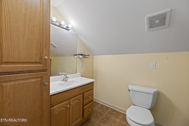 313 Lamar Ave, Clinton, TN 37716 - bathroom with vaulted ceiling, baseboards, toilet, vanity, and tile patterned flooring