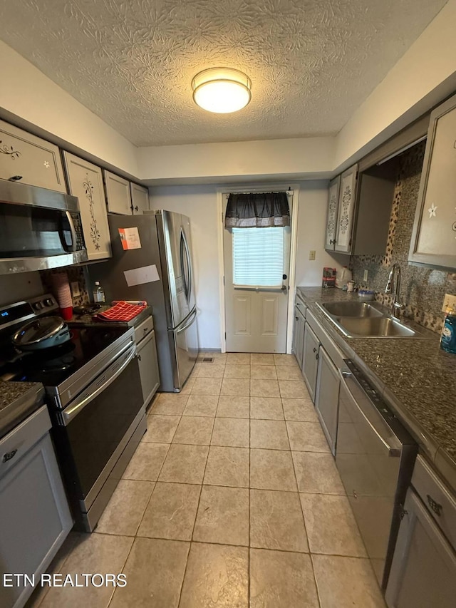 119 Hanover Pl, Oak Ridge, TN 37830 - kitchen featuring stainless steel appliances, a sink, dark countertops, a textured ceiling, and gray cabinetry