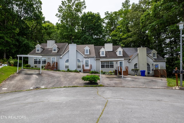 119 Hanover Pl, Oak Ridge, TN 37830 - new england style home featuring asphalt driveway, a chimney, view of scattered trees, and stucco siding