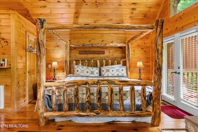 bedroom featuring wood walls, wood-type flooring, wooden ceiling, and access to outside