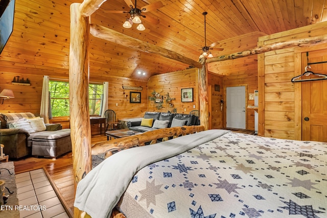 bedroom with vaulted ceiling, wood walls, and wood ceiling