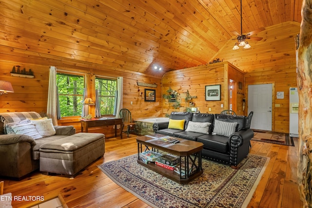 living area featuring lofted ceiling, wood walls, light wood-style floors, wooden ceiling, and ceiling fan