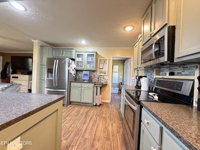 332 Tomlinson Rd, Pennington Gap, VA 24277 - kitchen featuring appliances with stainless steel finishes, ornamental molding, dark countertops, a textured ceiling, and tasteful backsplash