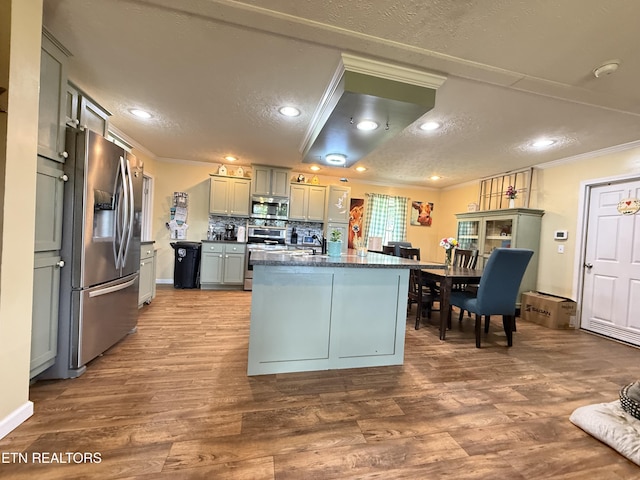 332 Tomlinson Rd, Pennington Gap, VA 24277 - kitchen featuring appliances with stainless steel finishes, dark countertops, ornamental molding, dark wood-type flooring, and a textured ceiling