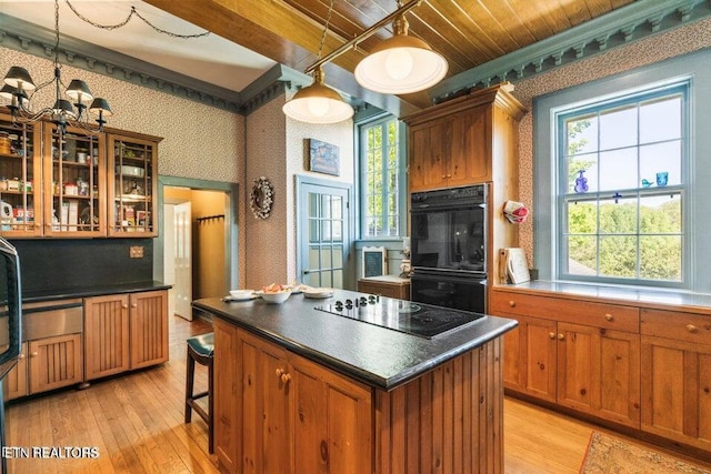 kitchen featuring black appliances, wallpapered walls, dark countertops, light wood-type flooring, and brown cabinets