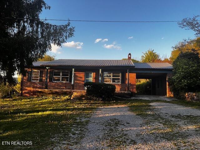 867 Pleasant Ridge Rd, Lafollette, TN 37766 - ranch-style home with driveway, a chimney, an attached carport, brick siding, and metal roof