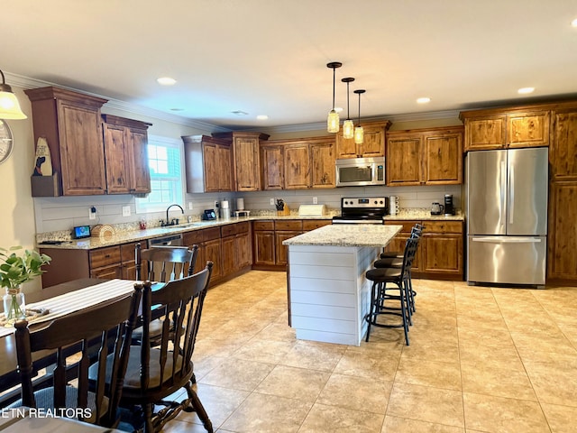 1617 Millstone Dr, Maryville, TN 37803 - kitchen featuring stainless steel appliances, ornamental molding, brown cabinets, hanging light fixtures, and a center island