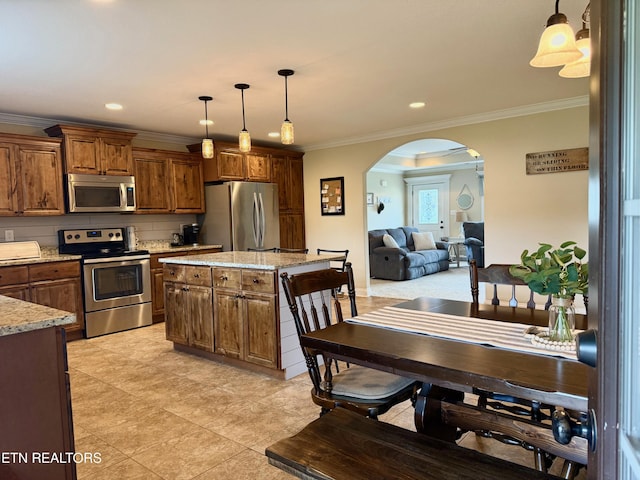 1617 Millstone Dr, Maryville, TN 37803 - kitchen with stainless steel appliances, arched walkways, ornamental molding, decorative light fixtures, and light stone countertops