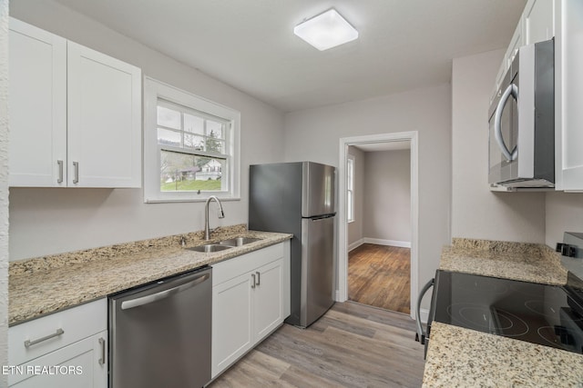 406 S Indiana Ave, Lafollette, TN 37766 - kitchen featuring stainless steel appliances, a sink, white cabinets, light wood-type flooring, and light stone countertops