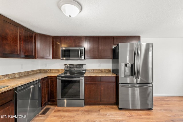 518 Church St, Vonore, TN 37885 - kitchen featuring stainless steel appliances, light wood-type flooring, dark brown cabinets, and baseboards