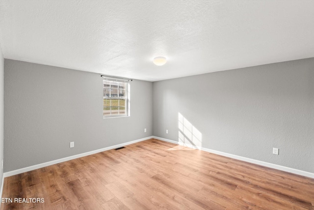 518 Church St, Vonore, TN 37885 - empty room with light wood finished floors, baseboards, and a textured ceiling