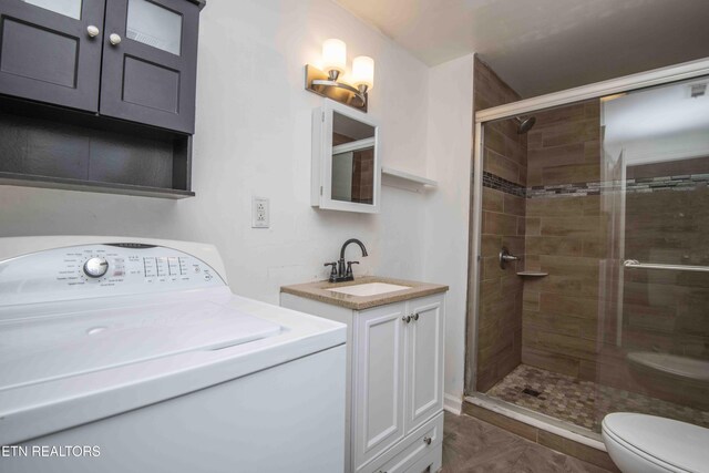 2918 Johnston St, Knoxville, TN 37921 - full bathroom with washer / dryer, a stall shower, toilet, and vanity