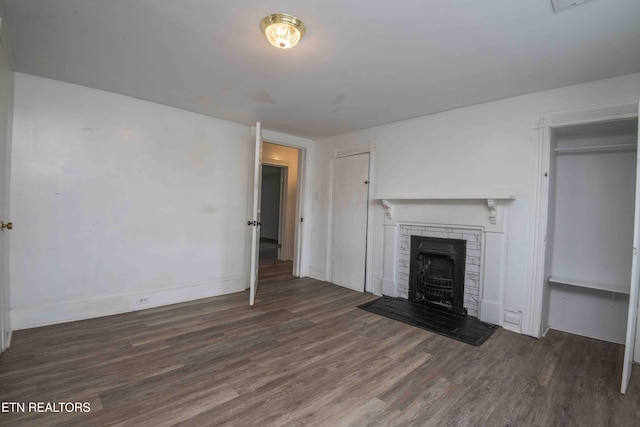2918 Johnston St, Knoxville, TN 37921 - unfurnished living room featuring wood finished floors, a brick fireplace, and baseboards
