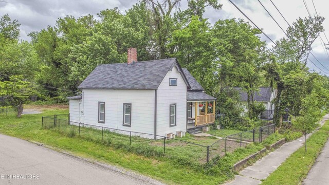 2918 Johnston St, Knoxville, TN 37921 - view of side of property featuring roof with shingles, a chimney, and covered porch