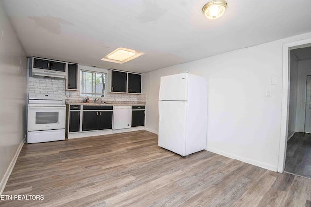 2918 Johnston St, Knoxville, TN 37921 - kitchen featuring white appliances, under cabinet range hood, light countertops, light wood-type flooring, and tasteful backsplash
