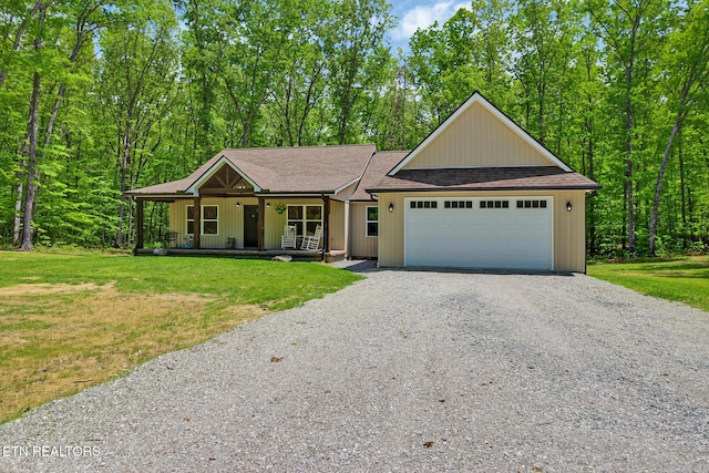 98 Paso Fino Trl, Jamestown, TN 38556 - view of front of house with gravel driveway, a porch, a front lawn, an attached garage, and roof with shingles