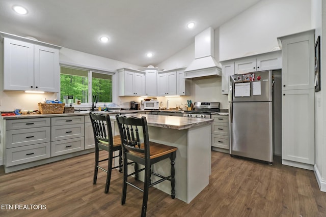 98 Paso Fino Trl, Jamestown, TN 38556 - kitchen featuring stainless steel appliances, custom range hood, lofted ceiling, a breakfast bar, and dark wood finished floors