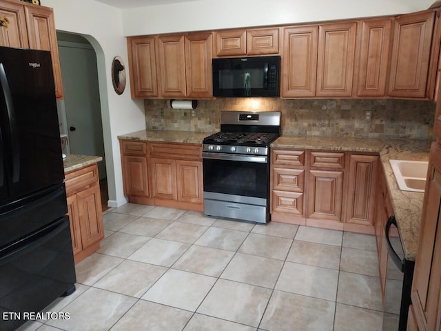 3381 Upper Caney Valley Rd, Tazewell, TN 37879 - kitchen featuring black appliances, backsplash, arched walkways, light stone countertops, and brown cabinets