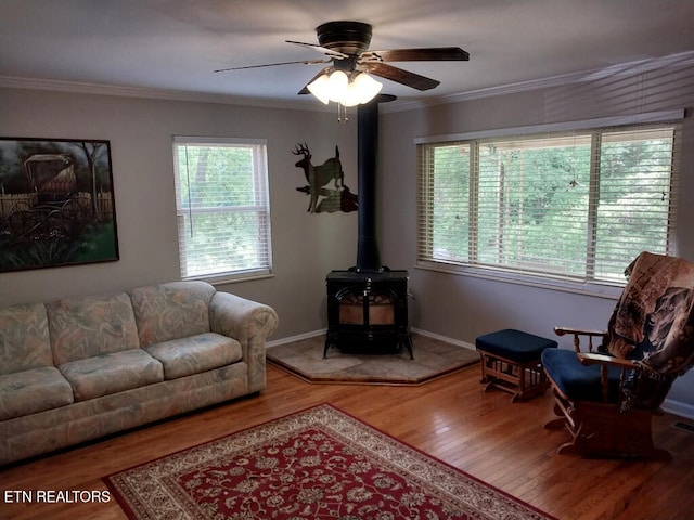3381 Upper Caney Valley Rd, Tazewell, TN 37879 - living room with wood finished floors, plenty of natural light, a wood stove, a ceiling fan, and crown molding