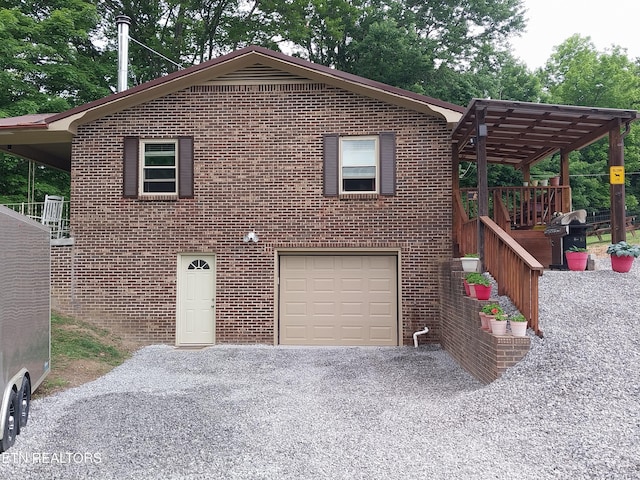 3381 Upper Caney Valley Rd, Tazewell, TN 37879 - view of front facade featuring a garage, brick siding, gravel driveway, and a pergola