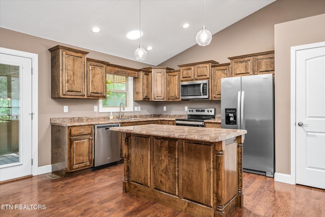 2689 Spruce Loop, Crossville, TN 38555 - kitchen featuring stainless steel appliances, a sink, vaulted ceiling, brown cabinetry, and dark wood finished floors