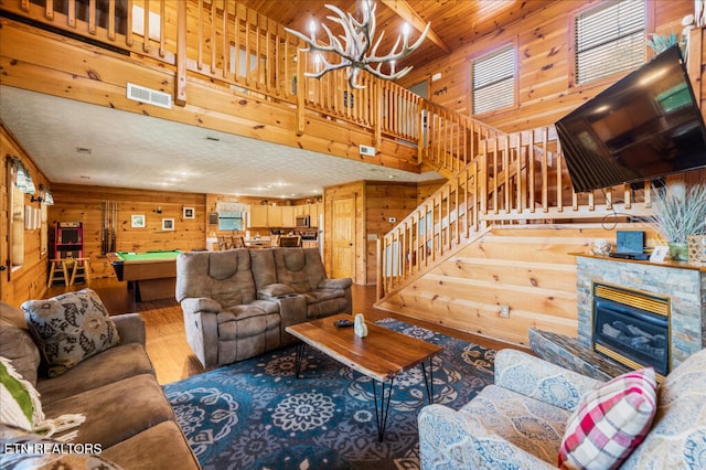 645 Wiley Oakley Dr, Gatlinburg, TN 37738 - living room with wood finished floors, wooden walls, a chandelier, pool table, and stairway